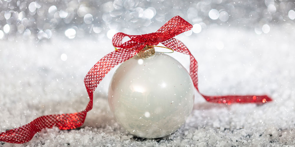 Boule de Noël blanche avec un ruban rouge