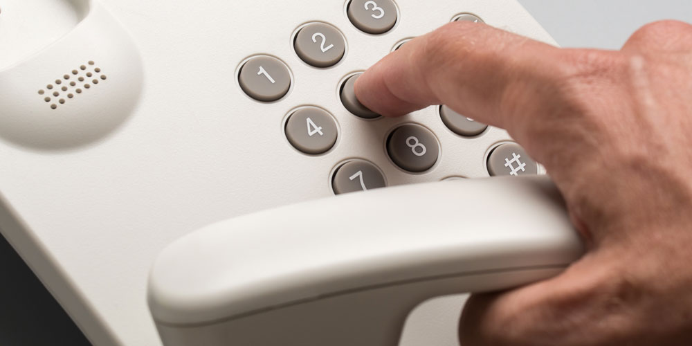 Homme qui compose un numéro de téléphone