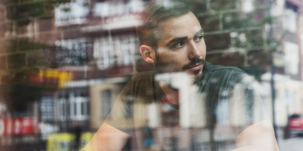 Homme qui regarde par la fenêtre