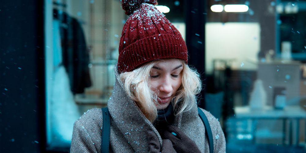 Femme les yeux fermés sous les flocons